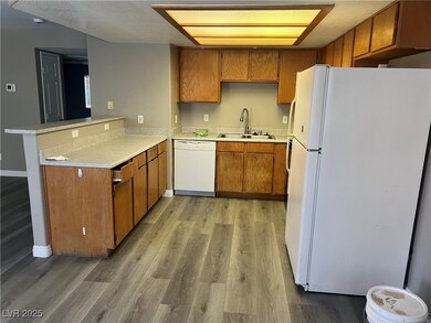 Kitchen with white appliances, brown cabinetry, li