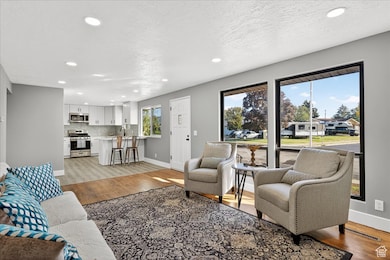 Living area with light wood-style floors, recessed lighting, and a textured ceiling