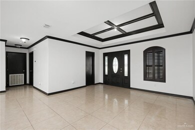 Foyer entrance with light tile flooring and crown molding
