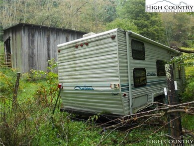 The camper and barn are located above the pasture