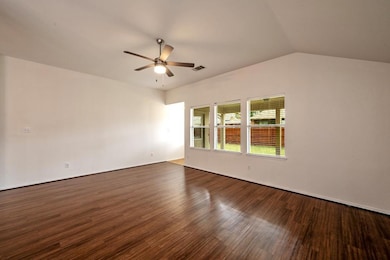 Empty room with ceiling fan, lofted ceiling, and d