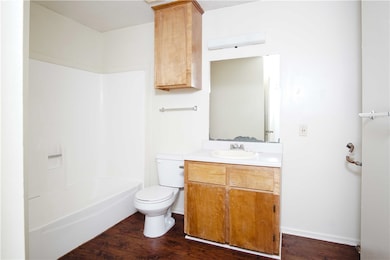 Bathroom with vanity, toilet, wood finished floors