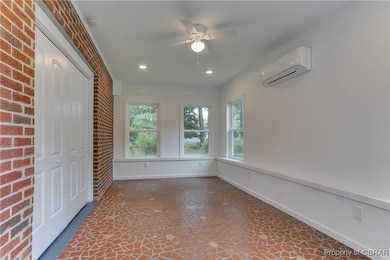 Unfurnished sunroom featuring a wall mounted AC, b