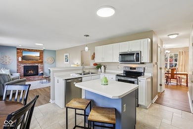 Updated kitchen offers center island, pendant lighting, Stainless Steet appliances, tile flooring, breakfast nook, and has a pantry