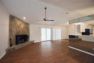 Unfurnished living room with a fireplace, dark wood finished floors, a ceiling fan, and vaulted ceiling