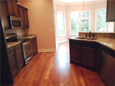 This is a good view of the GE stainless appliances, granite, undermount stainless sinks, and gleaming hardwoods in the kitchen.