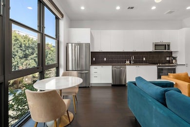 Kitchen featuring white cabinets, tasteful backsp