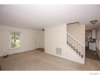 Living area is carpeted, view towards front door a