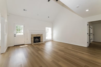 Unfurnished living room featuring a fireplace, hig