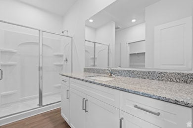 Bathroom with vanity, a stall shower, recessed lighting, visible vents, and wood finished floors