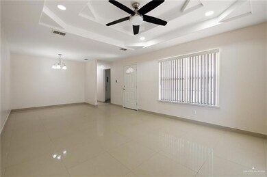 Empty room featuring recessed lighting, visible vents, a raised ceiling, and ceiling fan with notable chandelier