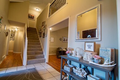 Two story tiled foyer with chandelier and carpeted