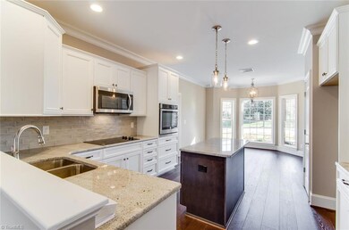 View from Family Room into kitchen & Dining area.  Earth tones highlight the granite countertops and backsplash.