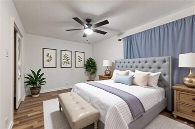 Bedroom featuring baseboards, wood finished floors, a closet, and ceiling fan