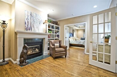 Entering the master suite with a sitting area and fireplace. You will see the master bedroom through the door past the chair. The master bath entrance is to the left of the fireplace.