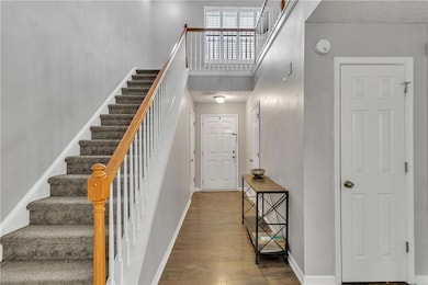 Staircase featuring a high ceiling, baseboards, an