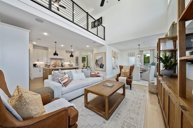 Living room featuring ceiling fan, a towering ceil