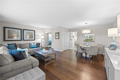 Living room with dark wood-type flooring and a cha