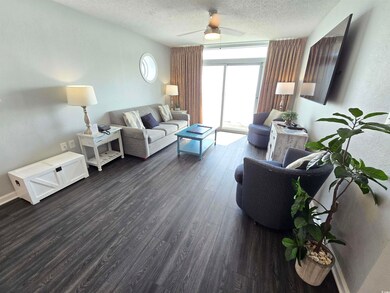 Living room featuring ceiling fan, dark hardwood /