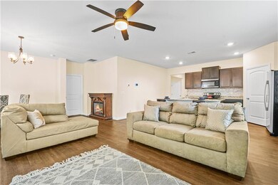 Living area with a ceiling fan, a chandelier, wood