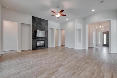 Unfurnished living room featuring a ceiling fan, 