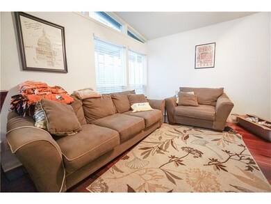 Living room featuring vaulted ceiling and wood fi