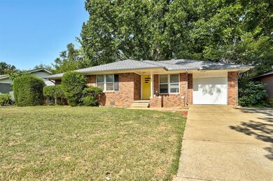 Single story home with a garage and a front lawn