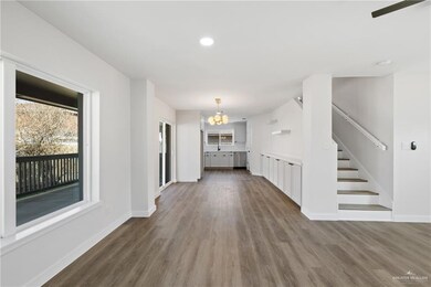 Unfurnished living room featuring dark hardwood / wood-style flooring and a notable chandelier