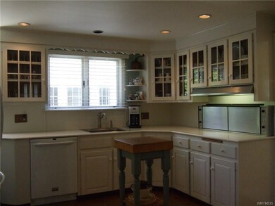 Huge kitchen has hardwood floors, corian counterto