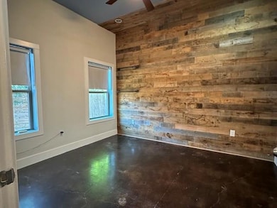 Unfurnished room with wooden walls, finished conc