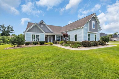 Craftsman house featuring board and batten siding, a front lawn, roof with shingles, and stone siding