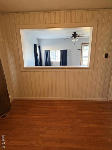 Unfurnished room featuring dark wood-type flooring and baseboards