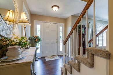 You're greeted at the front door with a hardwood floor, the staircase and the entrance to the living room.