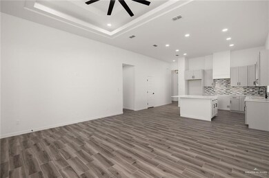 Unfurnished living room featuring recessed lighting, dark wood finished floors, and a tray ceiling