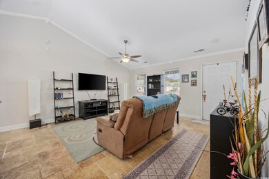 Living room featuring vaulted ceiling, ceiling fan