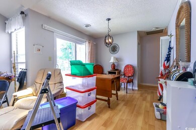 Playroom with a textured ceiling, light wood-type flooring, a chandelier, and baseboards