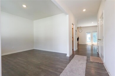 Corridor with dark wood-type flooring and recessed lighting