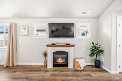 Living area with a glass covered fireplace and wood finished floors