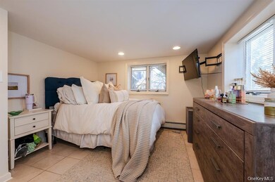 Bedroom with light tile patterned floors, baseboard heating, and recessed lighting
