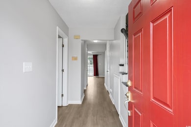 Hallway featuring baseboards, light wood-style flo