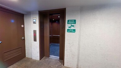 Hallway featuring a textured wall, concrete floor