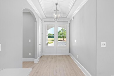 Foyer featuring crown molding, french doors, a cha