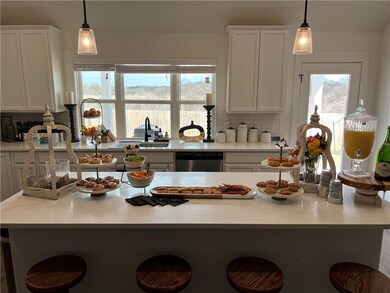 Kitchen with a breakfast bar, white cabinetry, and