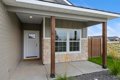 Property entrance with stone siding, a porch, and board and batten siding