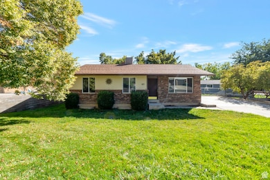 Ranch-style home featuring a front lawn and brick siding