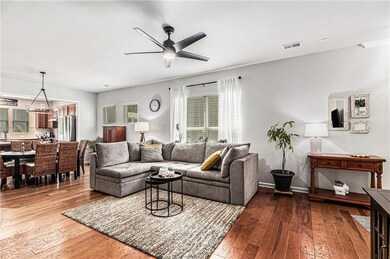 Living room featuring ceiling fan, hardwood / wood-style flooring, and baseboards