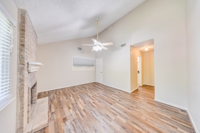 The spacious primary bedroom featuring high ceilings and a cozy fireplace adds a touch of warmth and character. The vinyl floors are a recent addition to make everyday cleaning a breeze.