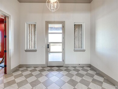 Entryway with a chandelier and baseboards