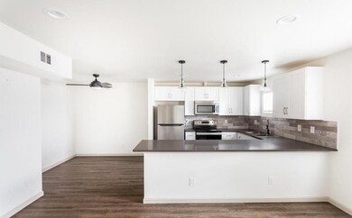 Kitchen featuring white cabinets, dark countertops