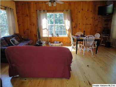 Living area open to kitchen area with wood floors.